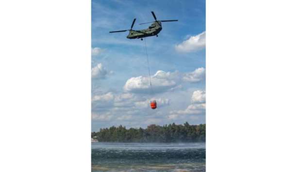 A helicopter is used to collect water from a lake to fight forest fires near Straelen, western Germany, yesterday, as the heatwave in Europe continues.