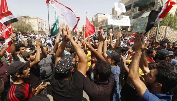 Iraqis shout slogans during ongoing protests in the southern city of Basra
