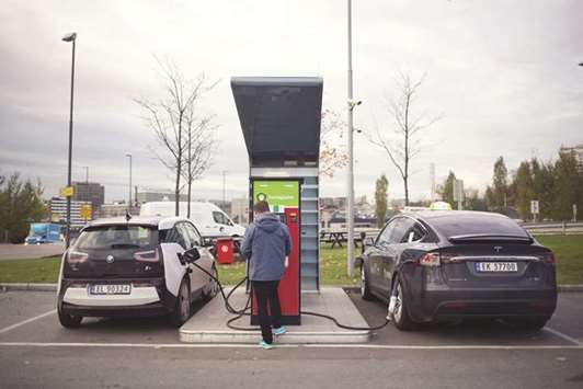 Electric automobiles manufactured by BMW (left) and Tesla sit at an electric vehicle charging station in Oslo. Tesla has sold more cars per capita in Norway than any other country in the world thanks to the governmentu2019s generous measures in favour of electric cars including tax exemptions, free city tolls and public parking.