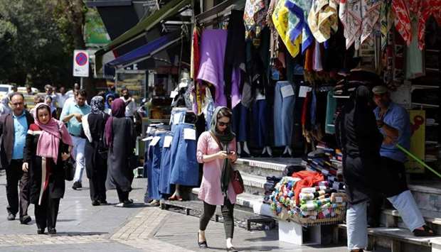 People walk in a shopping street in the Iranian capital Tehran on Monday 