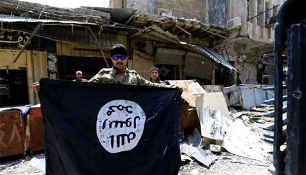 A member of the Emergency Response Division holds an Islamic State flag in the Old City of Mosul in July 2017. File picture