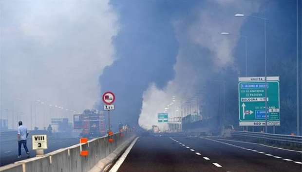 Firefighters work on the motorway after an accident caused a large explosion and fire at Borgo Panigale, on the outskirts of Bologna, Italy, on Monday.