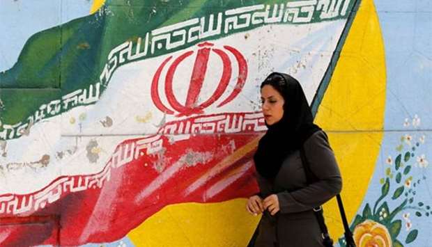 A woman walks in front of a mural painting depicting the Iranian flag, in Tehran on Monday. Iranian Foreign Minister Mohammad Javad Zarif said that the leaders of the United States, Saudi Arabia and Israel were isolated in their hostility to Iran.
