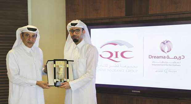 (From left) Ali Fadala, senior deputy Group president & CEO of QIC Group, hands over a token to Dreamau2019s Mohamed al-Khanji.