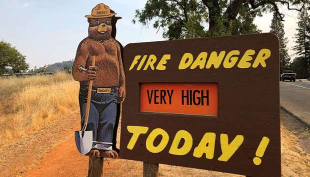 A sign by the side of the road warns of the threat of wildfires which have been fuelled by continued hot weather outside the town of Colfax, California, on Saturday.