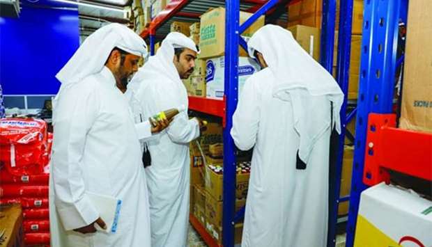 Inspectors from the Ministry of Economy and Commerce checking some products at a retail outlet in Souq Al Watan.