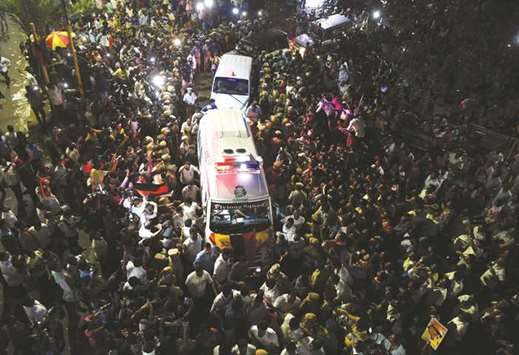 Dravida Munnetra Kazhagam (DMK) supporters gather around ambulance carrying mortal remains of party president M Karunanidhi from a hospital in Chennai yesterday.