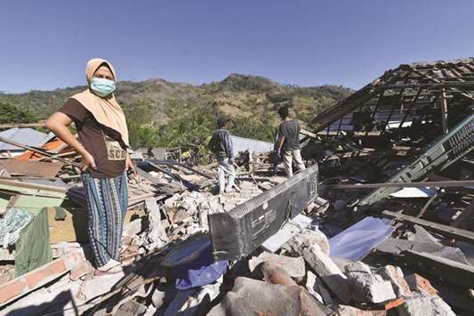 People search for their belongings through the rubble of damaged houses in north Lombok yesterday.