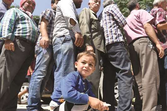 Displaced Syrians queue to receive aid in the northern Syrian town of Tal Rifaat yesterday.