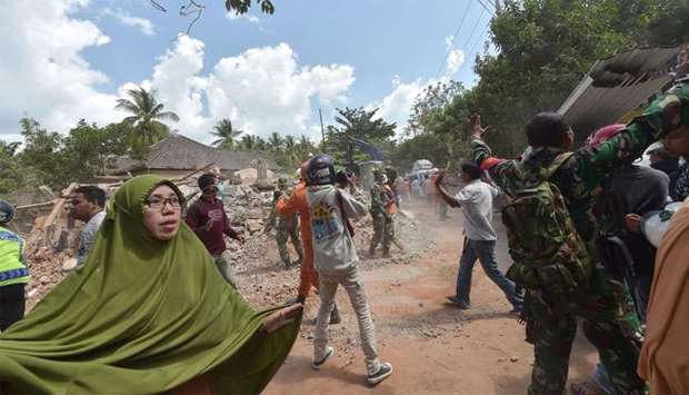 People react shortly after an aftershock hits the area in Tanjung on Lombok island