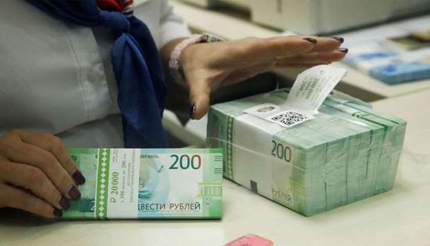 A cashier holds new 200 rouble banknotes in a bank in Moscow