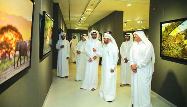 Qatari photographer Ali al-Shamsi shows his works to Katara general manager Dr Khalid bin Ibrahim al-Sulaiti during the opening of the u201cAfrican Safariu201d exhibition.