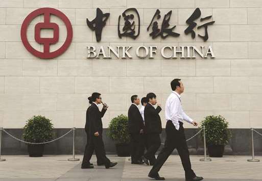 Bank workers walk outside the headquarters of the Bank of China in the Xidan district of Beijing. Hong Kongu2019s top banks, including the Bank of China, are hiking an important mortgage rate, piling pressure on borrowers and raising the risk of a slowdown in one of the worldu2019s most expensive property markets.