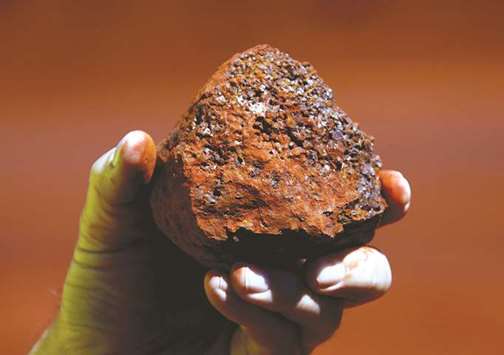 A miner holds a lump of iron ore at a mine located in the Pilbara region of Western Australia. Iron ore, which accounts for most of Riou2019s profit and is used in making steel, has provided healthy margins for years but the outlook is uncertain as major buyer China is expected to increasingly rely on recycling rather than importing raw material.