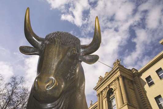 A bull statue is seen outside the entrance to the Frankfurt Stock Exchange. The DAX 30 ended 0.3% up at 12,676.11 points yesterday.