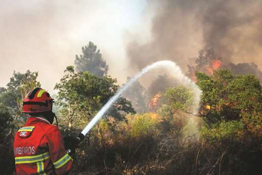 A firefighter combats a wildfire close to Monchique in the Portuguese Algarve.