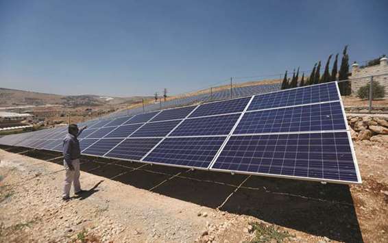 A Palestinian engineer stands next to solar panels in Tubas, in the occupied West Bank.