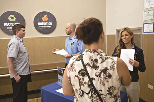 Managers speak with job seekers during a hiring event at a supermarket in Darien, Illinois. Labour market strength and rising inflation likely keep the Federal Reserve on track to raise interest rates in September for the third time this year.