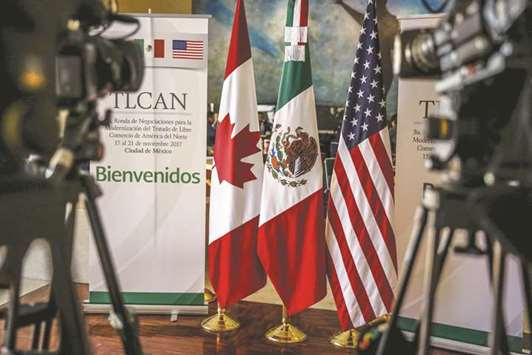 Canadian, Mexican, and American flags on display during the Nafta negotiations in Mexico City. Getting an agreement on automobiles would let the US turn its attention to demands that only affect Canada, such as increasing American access to the dairy market north of the border.