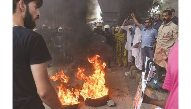 Supporters of the PML-N gather beside burning tyres during a protest in Lahore against the arrest of Maryam Nawaz.