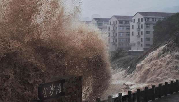 Waves hit a sea wall in front of buildings in Taizhou, China's eastern Zhejiang province