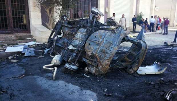 People gather at the site where a car bomb exploded in Benghazi, Libya