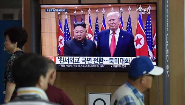 People watch a television news screen showing file footage of a meeting between US President Donald Trump and North Korean leader Kim Jong Un which was held at the truce village of Panmunjom in the DMZ, at a railway station in Seoul on August 10, 2019