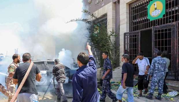 Libyan firefighters extinguish a fire at the site of car bomb attack in Libya's eastern city of Benghazi