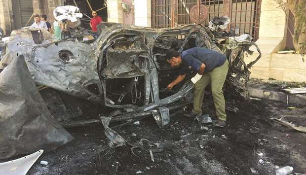 A security official inspects the site where a car bomb exploded in Benghazi yesterday.