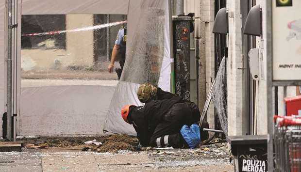 Police technicians work outside a local police station in Copenhagen after the building was hit by an explosion.