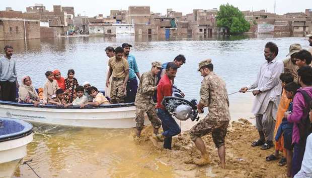 Soldiers use a boat to evacuate local residents from floodwaters after heavy monsoon rains in Hyderabad yesterday, some 160km east of the southern port city of Karachi.