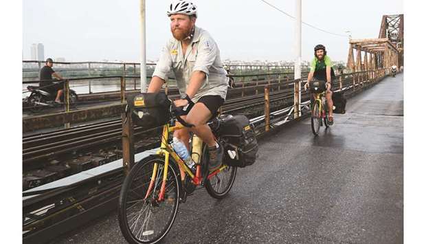 Rugby enthusiasts Ron Rutland (left) and James Owens ride on the Long Bien Bridge in Hanoi, Vietnam, on their way from Twickenham to the Rugby World Cup in Tokyo. (AFP)