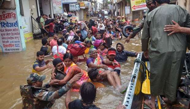 Indian Army personnel rescue people stranded in flood waters after heavy rains on the outskirts of Sangli in Maharashtra state