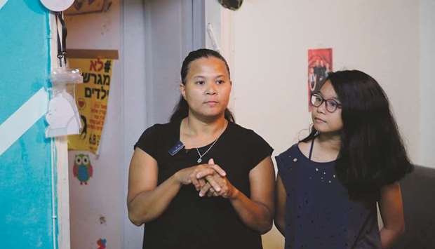 Ramela Noel (left), a Filipina domestic worker, stands with her daughter, 11-year-old Sivan, during an interview at their home in Tel Aviv.