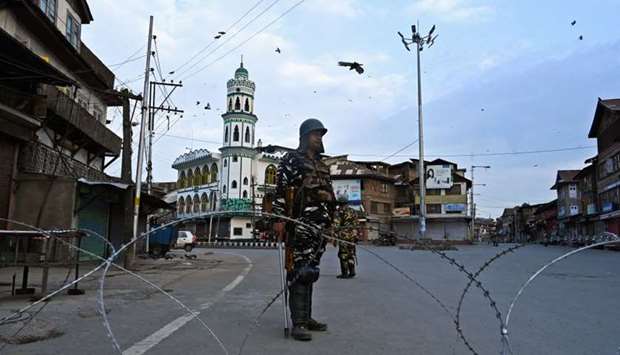 Security personnel stand guard on a street during a lockdown in Srinagar.