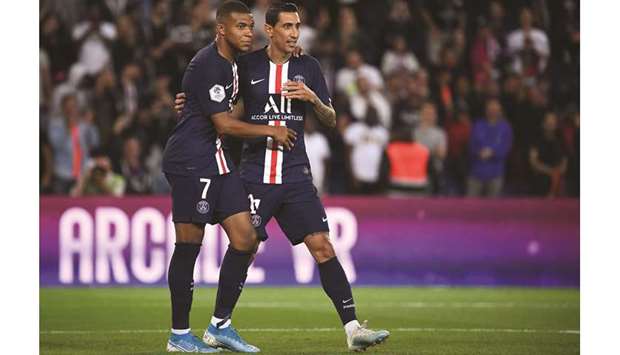 Paris Saint-Germainu2019s Angel Di Maria (right) is congratulated by teammate Kylian Mbappe after scoring a goal during the Ligue 1 match against Nimes Olympique in Paris, France, on Sunday. (AFP)