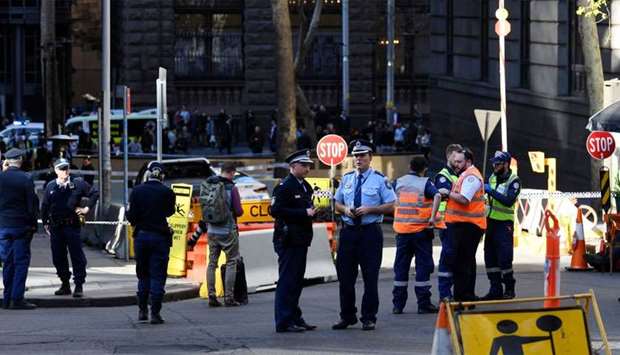 Police officers investigate near the scene of a knife rampage in Sydney