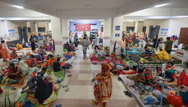 Bangladeshi patients suffering from dengue fever rest on the floor of a ward at the Mugda Medical College and Hospital in Dhaka