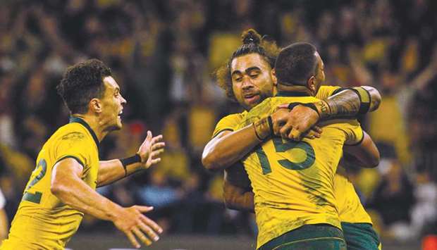 Australiau2019s Kurtley Beale (right) celebrates with teammates Lukhan Salakaia (centre) and Matt Toomua (left) after scoring a try against New Zealand during their Rugby Championship Bledisloe Cup match in Perth, Australia, on Saturday. (AFP)
