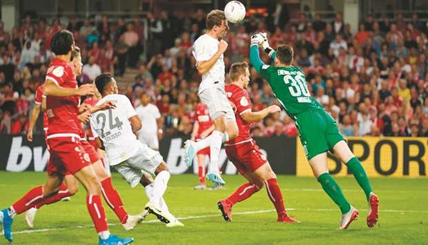 Cottbusu2019 goalkeeper Lennart Moser (right) and Bayern Munichu2019s German forward Thomas Mueller vie for the ball during the German Cup match on Monday. (AFP)