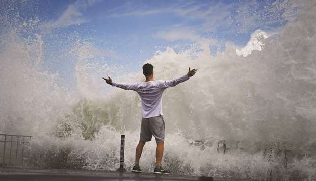 A man reacts as waves crash against the seafront on Enoshima Island on the coast of Kanagawa prefecture, southwest of Tokyo, yesterday.