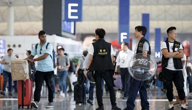 Police patrol the departure hall of the airport in Hong Kong after previous night's clashes with protesters