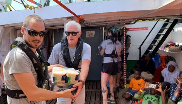 US actor Richard Gere helps to carry supplies aboard Open Arms rescue boat at Mediterranean sea in this picture provided by the Spanish NGO Open Arms on August 9