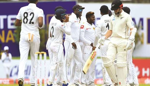 Sri Lankan bowler Akila Dananjaya (centre) celebrates with teammates after dismissing New Zealand captain Kane Williamson (right) during the first day of the opening Test at the Galle International Cricket Stadium in Galle yesterday. (AFP)