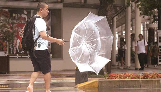 A man makes his way amid strong wind by typhoon Krosa in Miyazaki, Japan.