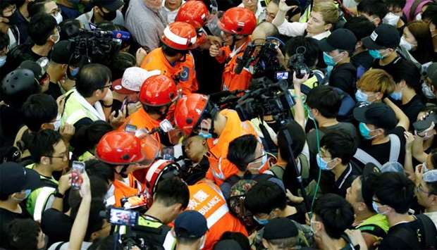 Medics attempt to remove an injured man who anti-government protesters said was an undercover policeman at the airport in Hong Kong