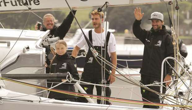 Swedish teenage climate activist Greta Thunberg and crew members Pierre Casiraghi and Boris Herrmann wave from the Malizia II boat in Plymouth, at the start of a trans-Atlantic boat trip to New York.