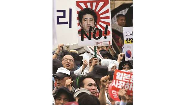South Korean protesters hold a placard showing a picture of Japanese Prime Minister Shinzo Abe during an anti-Japanese rally marking the anniversary of Koreau2019s liberation from Japanu2019s 1910-45 colonial rule, in central Seoul yesterday.