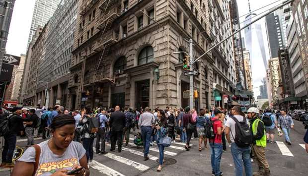 Commuters are seen on Fulton Street after the Fulton Street subway station was closed as police investigated two suspicious packages in Manhattan, New York