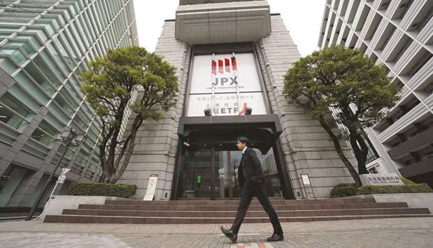 A pedestrian walks past the Tokyo Stock Exchange building in Japan. The Nikkei 225 ended flat at 20,418.81 points yesterday.